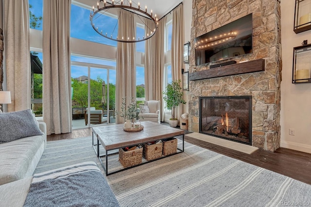 5428 Forest View Rd, Parker, CO 80134 - living room with wood finished floors, a towering ceiling, a stone fireplace, and baseboards