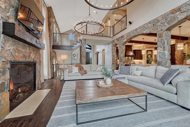 5428 Forest View Rd, Parker, CO 80134 - living area featuring a high ceiling, hardwood / wood-style flooring, arched walkways, ornate columns, and a chandelier