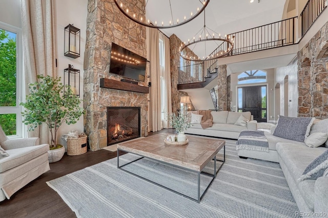 5428 Forest View Rd, Parker, CO 80134 - living area featuring a high ceiling, wood finished floors, a chandelier, and a stone fireplace