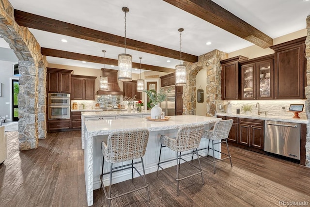 5428 Forest View Rd, Parker, CO 80134 - kitchen featuring appliances with stainless steel finishes, custom range hood, a large island, backsplash, and beamed ceiling