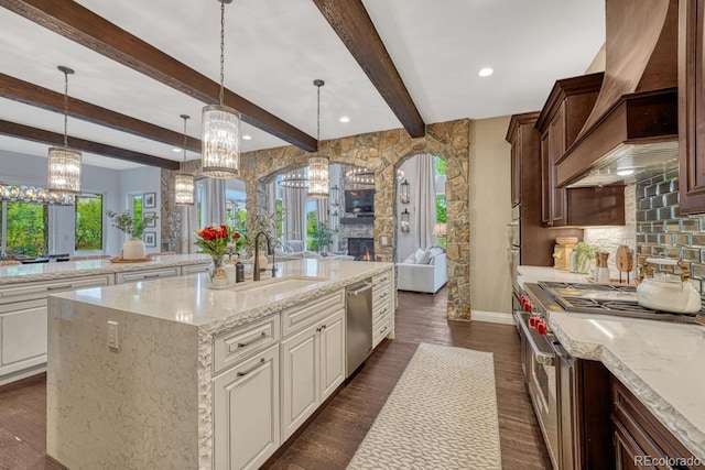 5428 Forest View Rd, Parker, CO 80134 - kitchen with a sink, stainless steel appliances, a chandelier, custom range hood, and light stone countertops