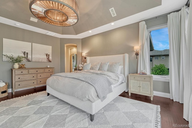 5428 Forest View Rd, Parker, CO 80134 - bedroom featuring arched walkways, wood finished floors, a tray ceiling, baseboards, and recessed lighting