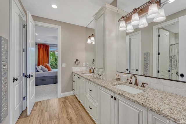 5428 Forest View Rd, Parker, CO 80134 - ensuite bathroom with double vanity, wood finished floors, baseboards, curtained shower, and recessed lighting