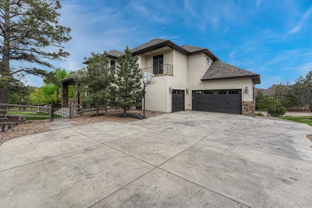 5428 Forest View Rd, Parker, CO 80134 - view of side of home with stucco siding, a balcony, driveway, stone siding, and a gate