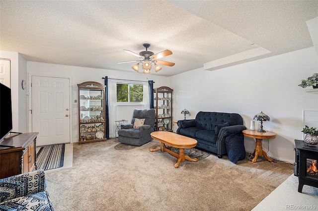 carpeted living area featuring a textured ceiling and ceiling fan