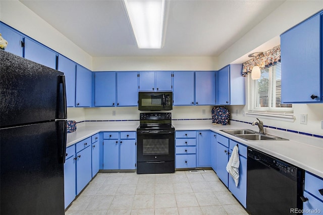 kitchen featuring black appliances, blue cabinetry, light countertops, and a sink