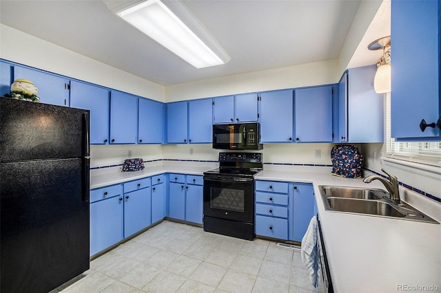 kitchen with black appliances, blue cabinetry, light countertops, and a sink