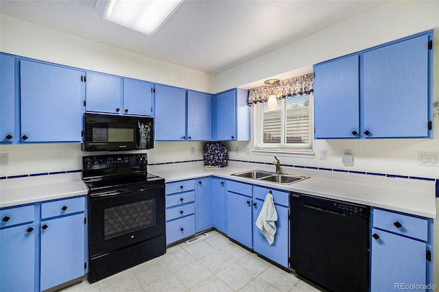 kitchen with black appliances, blue cabinetry, light countertops, and a sink