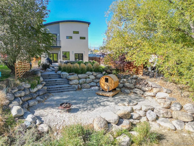 exterior space featuring a balcony and a fire pit