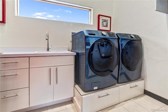 laundry area featuring plenty of natural light, washer and dryer, light tile patterned floors, and sink