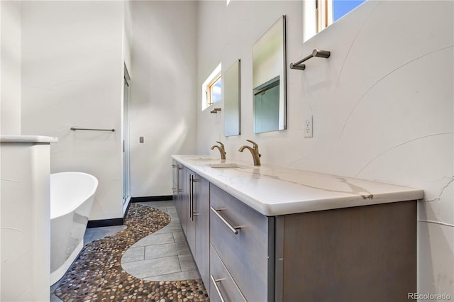 bathroom with tile patterned flooring, vanity, and a tub