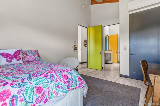 bedroom with light hardwood / wood-style floors and a wall mounted AC