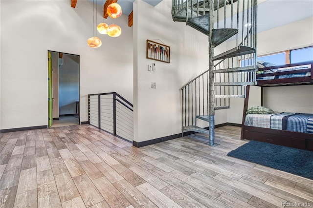 stairs featuring hardwood / wood-style flooring and a high ceiling