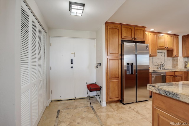 3131 E Alameda Ave Unit 1003, Denver, CO 80209 - kitchen with appliances with stainless steel finishes, tasteful backsplash, light stone counters, recessed lighting, and brown cabinets