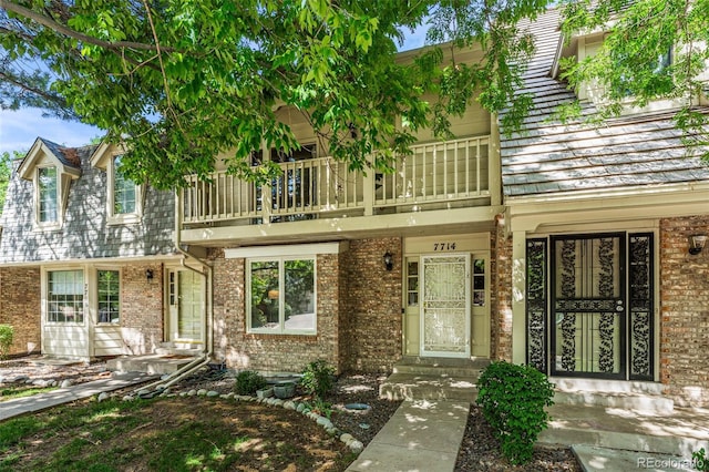 view of front of property with a balcony and brick siding