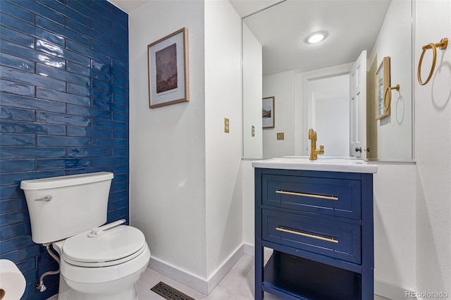 half bath featuring baseboards, visible vents, toilet, tile patterned flooring, and vanity