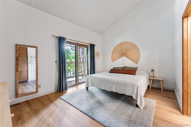 bedroom featuring light wood-type flooring, access to outside, high vaulted ceiling, and baseboards