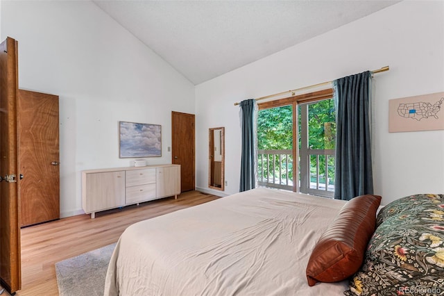 bedroom featuring light wood-style flooring and high vaulted ceiling