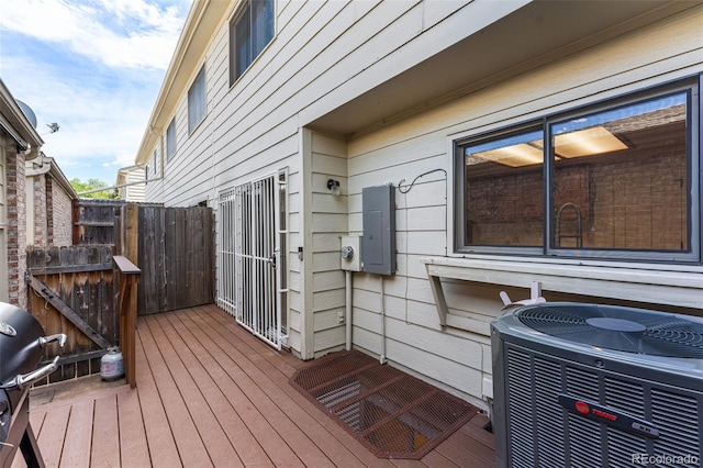 wooden terrace with cooling unit and fence