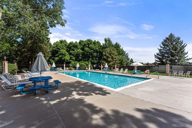 community pool with fence and a patio