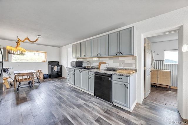 kitchen featuring gray cabinets, a sink, black appliances, and wood finished floors