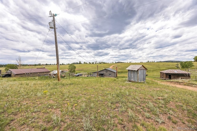 view of yard featuring an outdoor structure and a rural view