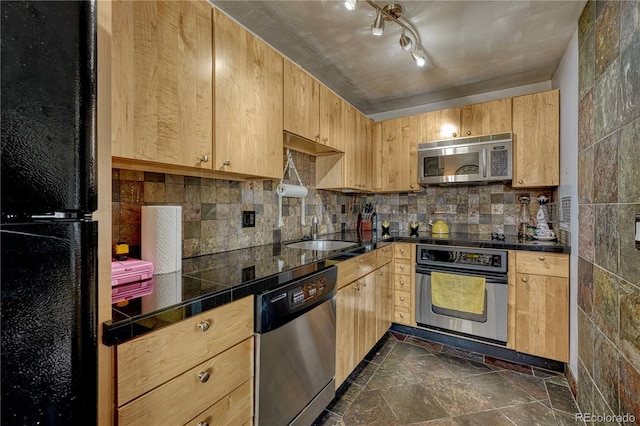 kitchen featuring light brown cabinets, a sink, appliances with stainless steel finishes, tasteful backsplash, and stone finish floor