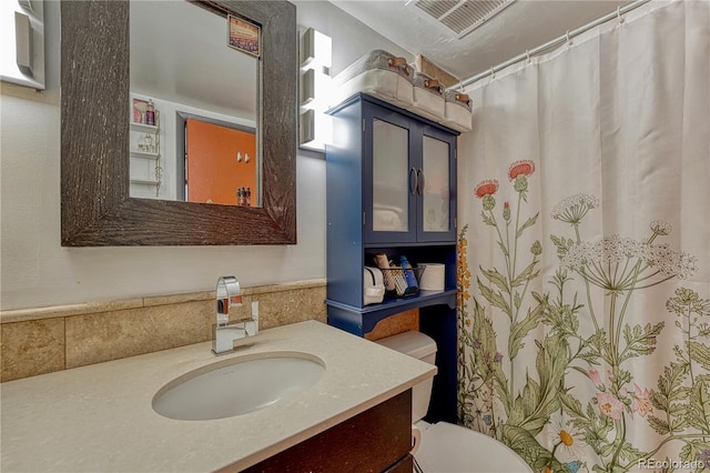 full bath with curtained shower, visible vents, vanity, and toilet