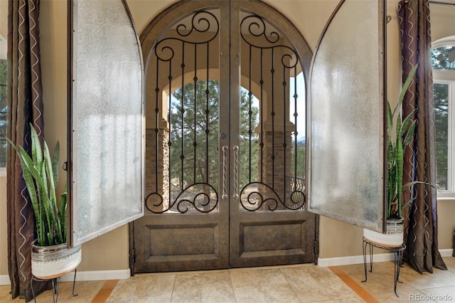 8320 Red Spring Valley Rd, Colorado Springs, CO 80919 - foyer with french doors, arched walkways, baseboards, and tile patterned floors