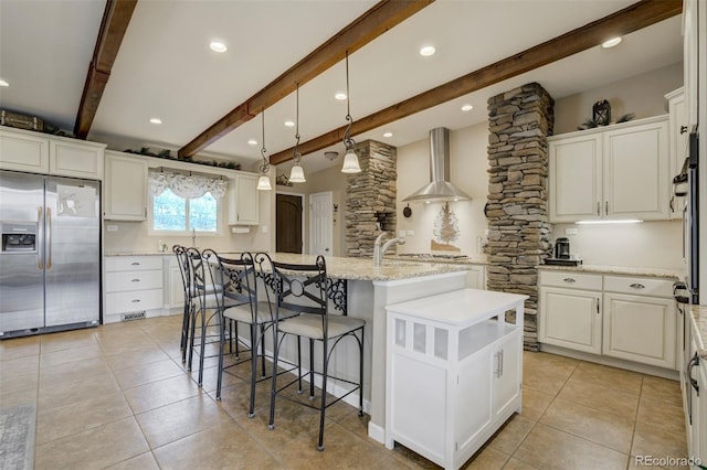 8320 Red Spring Valley Rd, Colorado Springs, CO 80919 - kitchen featuring stainless steel refrigerator with ice dispenser, white cabinetry, an island with sink, light tile patterned floors, and beam ceiling