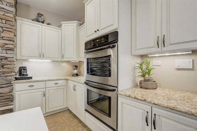 8320 Red Spring Valley Rd, Colorado Springs, CO 80919 - kitchen with stainless steel double oven, white cabinetry, and light tile patterned floors
