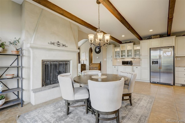 8320 Red Spring Valley Rd, Colorado Springs, CO 80919 - dining area featuring arched walkways, beamed ceiling, light tile patterned floors, a chandelier, and a fireplace