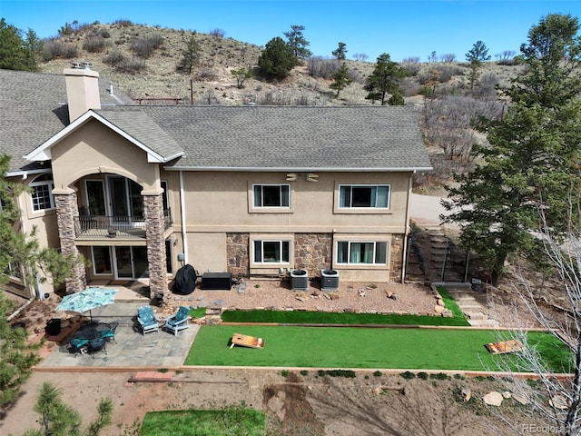 8320 Red Spring Valley Rd, Colorado Springs, CO 80919 - back of property featuring a balcony, stucco siding, roof with shingles, stone siding, and a patio