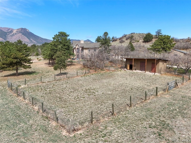 8320 Red Spring Valley Rd, Colorado Springs, CO 80919 - view of yard with an outdoor structure, a mountain view, fence, and an outbuilding