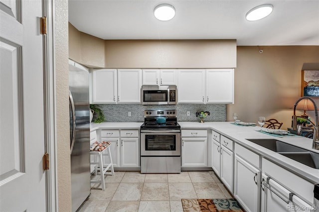 2428 W 82nd Pl Unit 1D, Westminster, CO 80031 - kitchen with appliances with stainless steel finishes, decorative backsplash, white cabinetry, and light countertops
