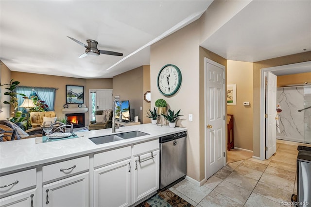 2428 W 82nd Pl Unit 1D, Westminster, CO 80031 - kitchen featuring dishwasher, a ceiling fan, a warm lit fireplace, open floor plan, and light countertops