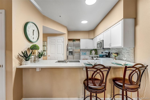 2428 W 82nd Pl Unit 1D, Westminster, CO 80031 - kitchen with stainless steel appliances, a peninsula, backsplash, white cabinets, and light countertops