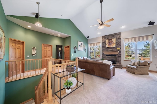 living room with high vaulted ceiling, light colored carpet, ceiling fan, and a fireplace