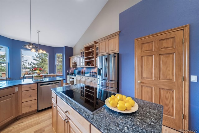 kitchen featuring a center island, decorative light fixtures, stainless steel appliances, light hardwood / wood-style floors, and vaulted ceiling