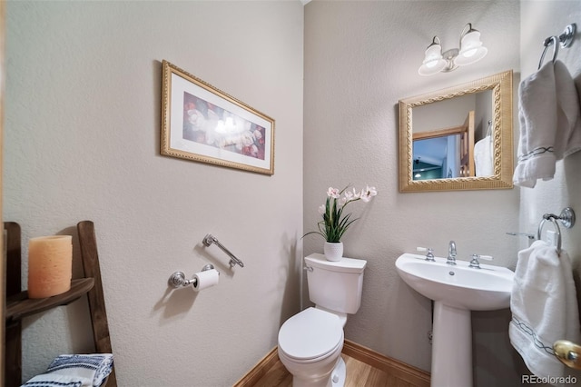 bathroom featuring hardwood / wood-style floors and toilet