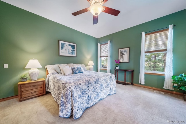 bedroom featuring light carpet, multiple windows, and ceiling fan