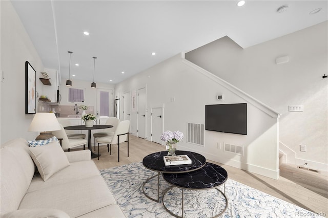 living room featuring recessed lighting, visible vents, and light wood finished floors