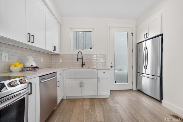 1907 W Elk Pl, Denver, CO 80211 - kitchen with appliances with stainless steel finishes, light wood finished floors, and white cabinets