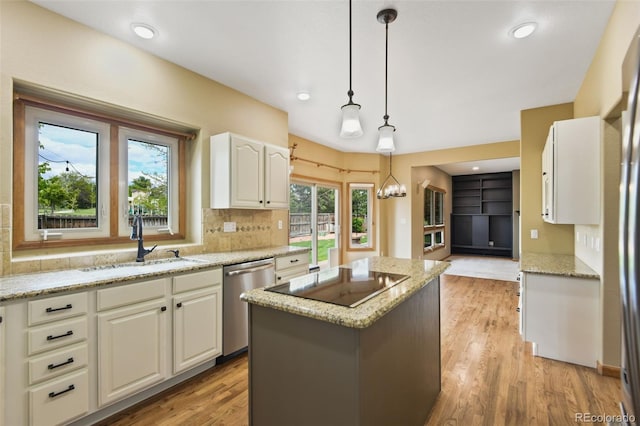 8286 W 108th Pl, Westminster, CO 80021 - kitchen featuring dishwasher, black electric stovetop, a kitchen island, light stone counters, and white cabinetry