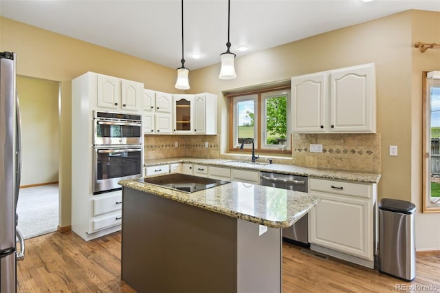 8286 W 108th Pl, Westminster, CO 80021 - kitchen with stainless steel appliances, tasteful backsplash, light stone counters, white cabinets, and a center island
