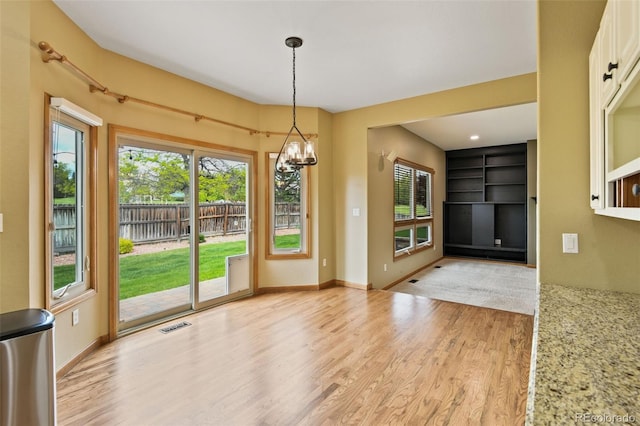 8286 W 108th Pl, Westminster, CO 80021 - unfurnished dining area featuring light wood-type flooring, a chandelier, and plenty of natural light