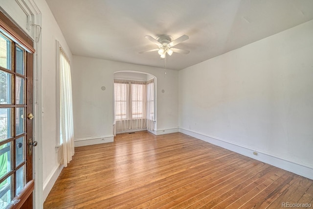 332 F St, Salida, CO 81201 - spare room featuring light wood-style flooring, arched walkways, a ceiling fan, and baseboards