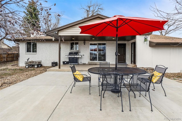 view of patio featuring fence, outdoor dining space, and grilling area