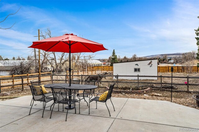 14290 W 54th Ave, Arvada, CO 80002 - fenced backyard featuring outdoor dining area, a patio area, and an outbuilding