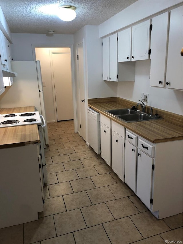 kitchen featuring sink, white appliances, white cabinetry, and light tile floors